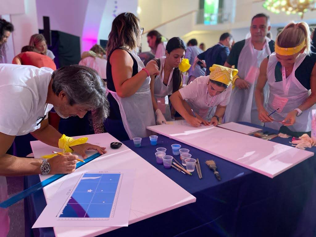 Team al lavoro con grembiuli protettivi su un progetto di pittura collaborativa