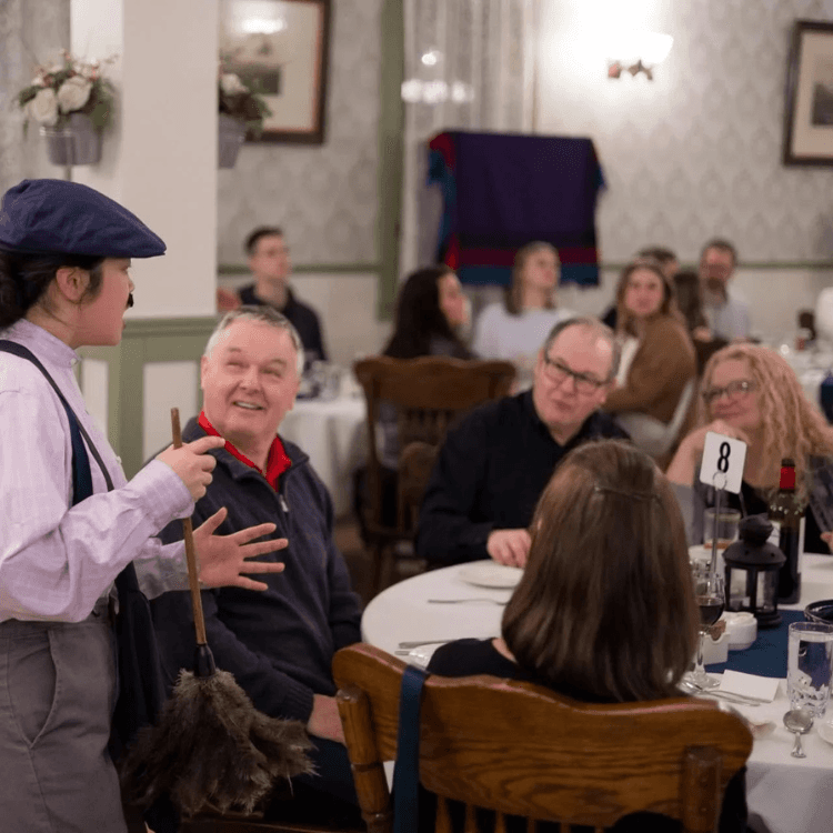 Attore interagisce con gli ospiti durante una cena con delitto